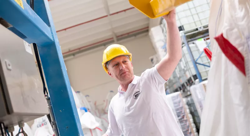 Employee with helmet at the production with Bekina Compounds